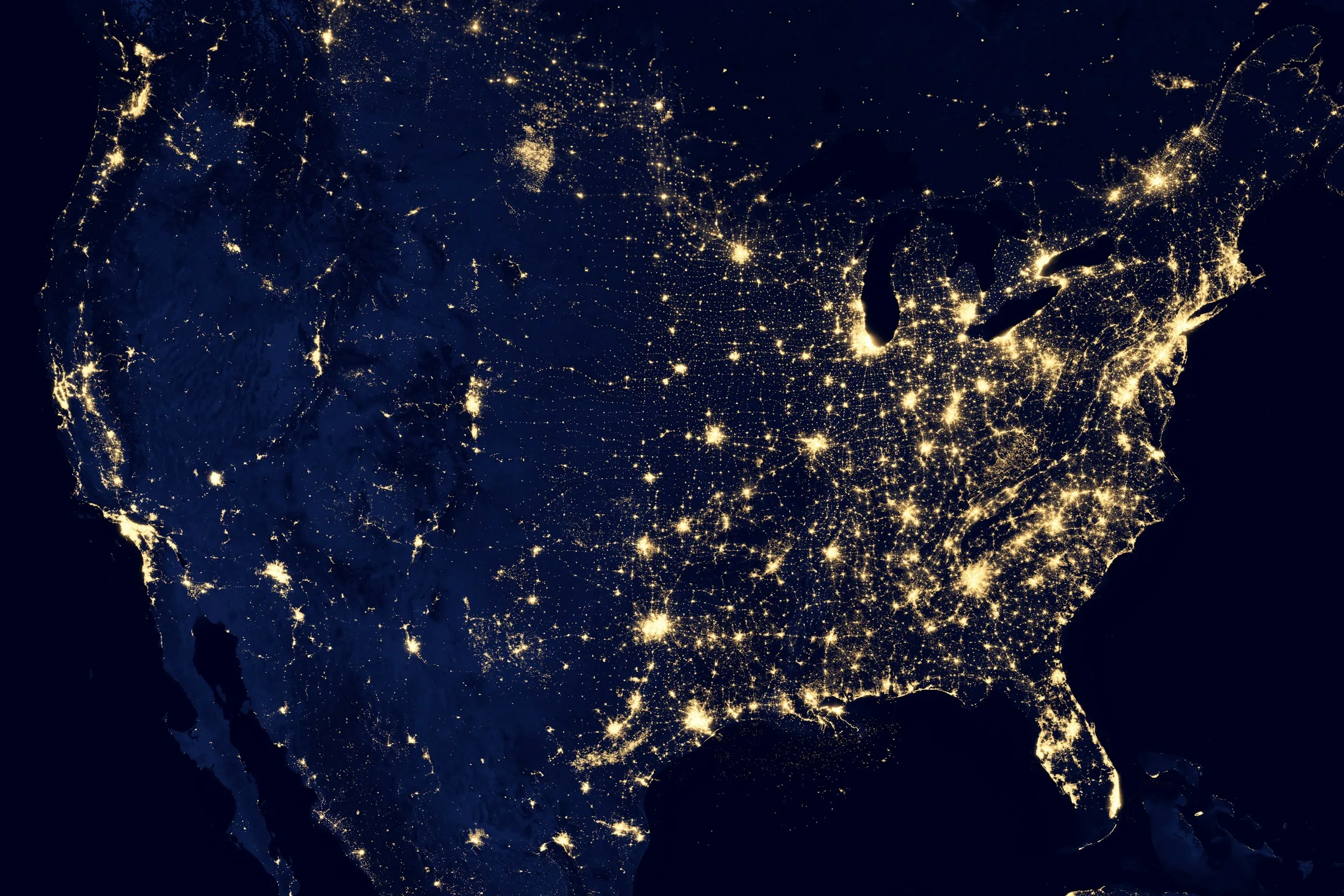 Map of the United States illuminated at night representing federal AI policy
